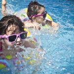 Kleine Kinder schwimmen in Pool