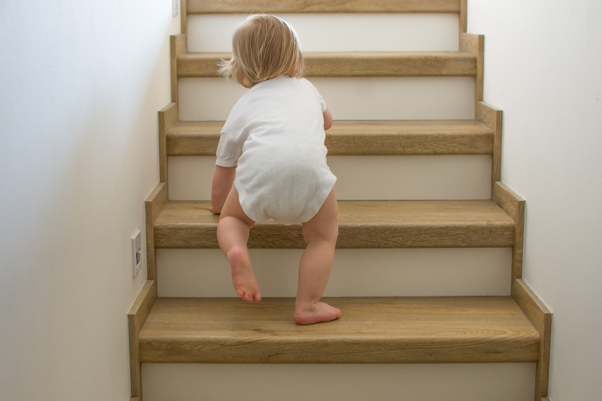 Kleinkind krabbelt zu Hause auf einer Treppe