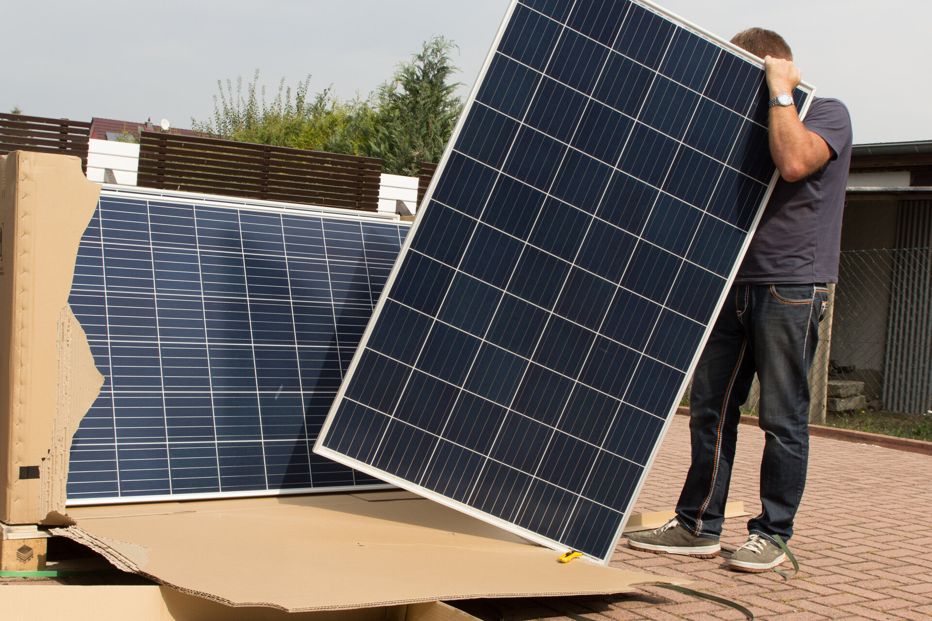 Mann hantiert mit Solarplatten für grüne Energie